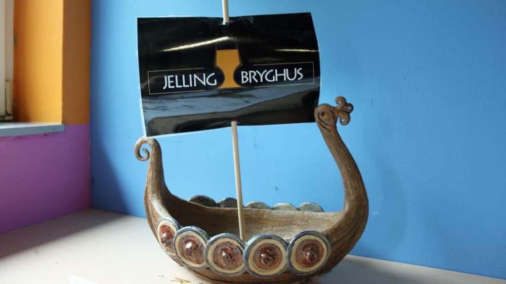 Das Logo von Jelling Bryghus und ein Wikingerschiff